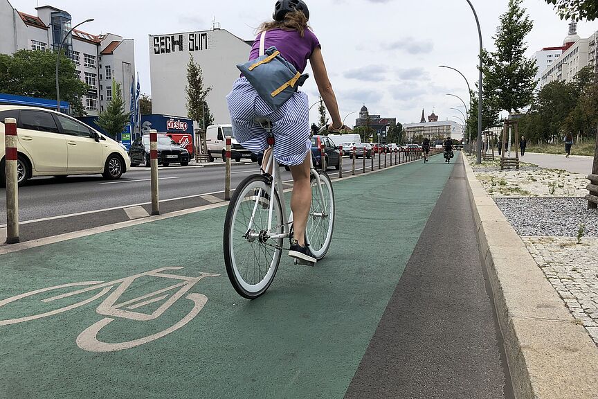 Frau auf geschütztem Radfahrstreifen Frau auf geschütztem Radfahrstreifen